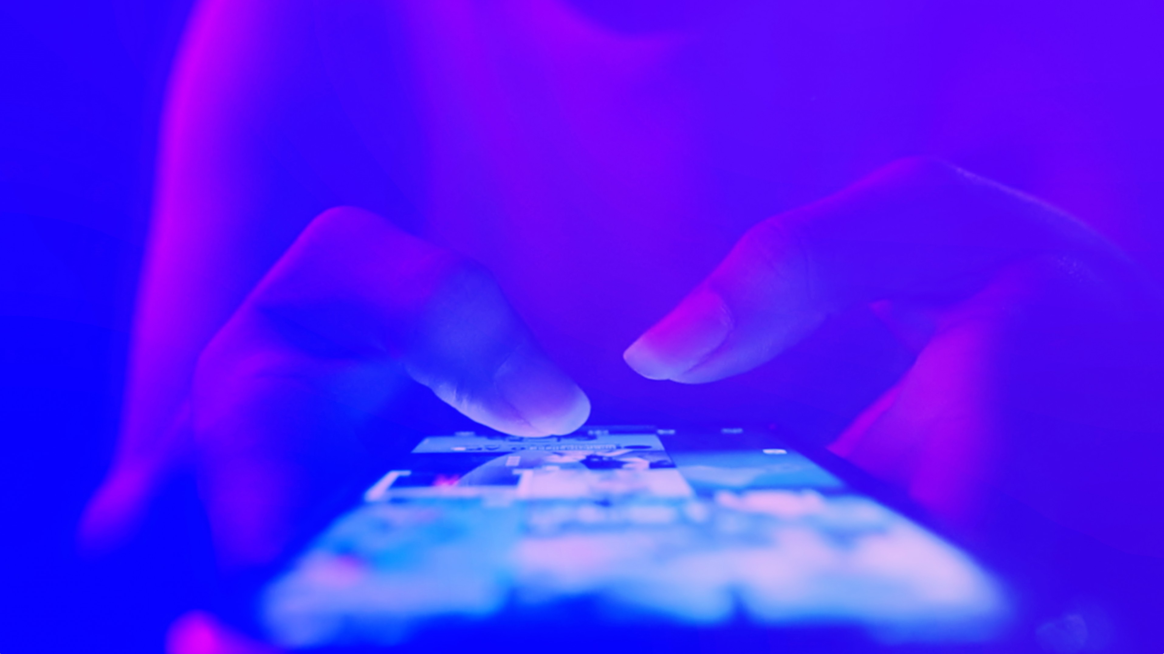 Hands scrolling through a social media feed